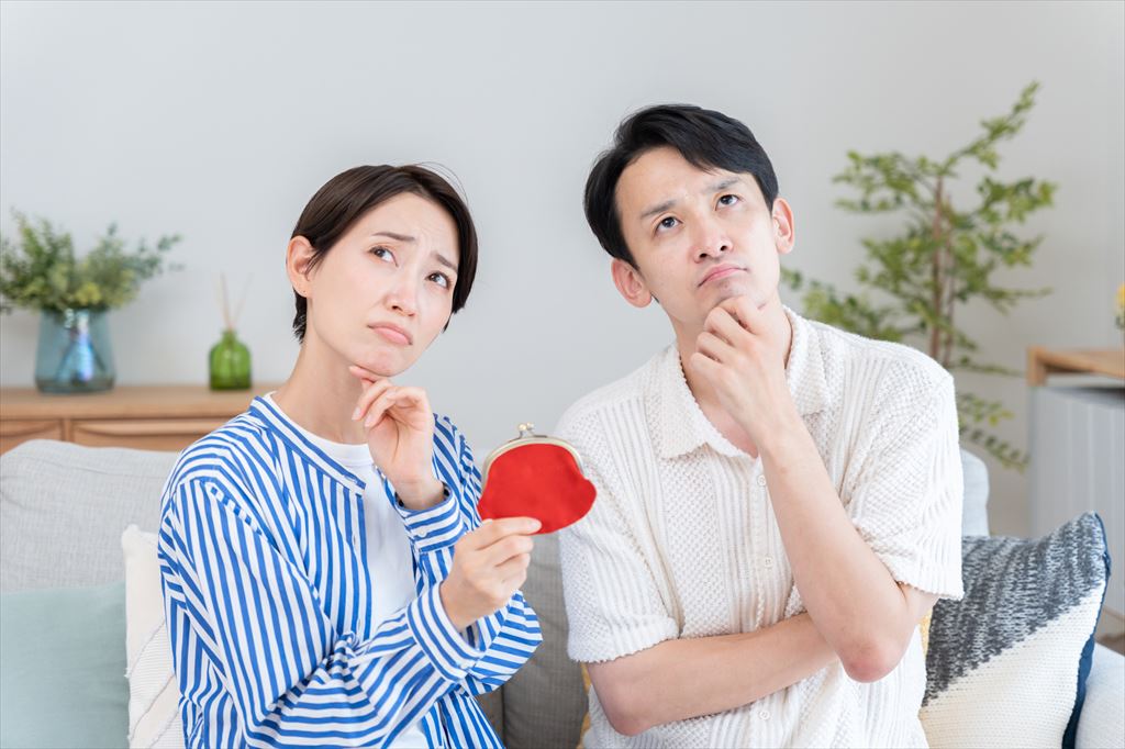 財布を手にお金がないことを悩む夫婦