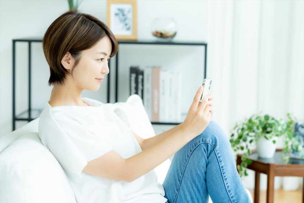 スマートフォンを持つ女性_日常生活の場面